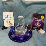 Illustration de la santé cellulaire au naturel : carafe d'eau Aladin, compléments alimentaires, livres de référence et cristaux énergétiques sur fond apaisant
